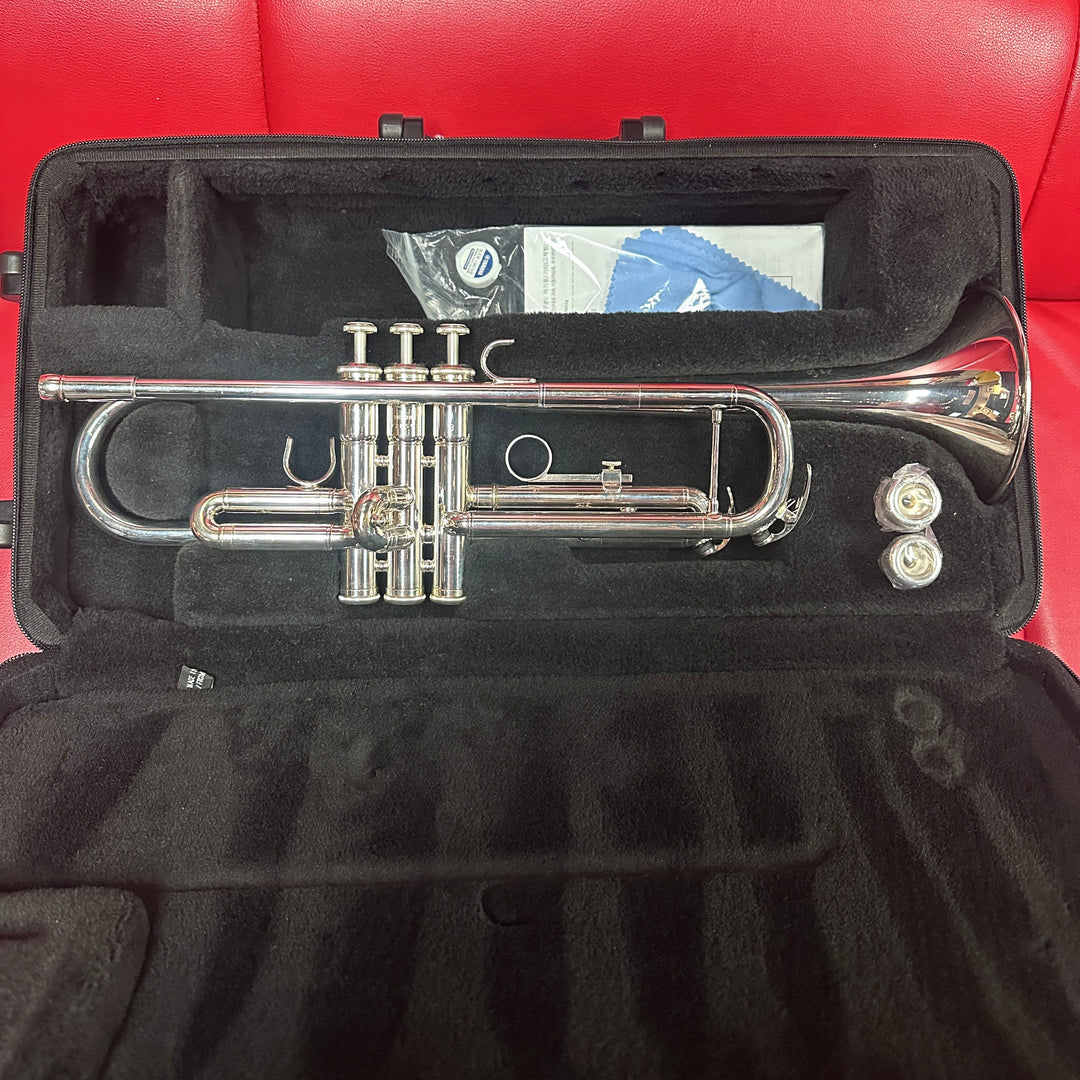 Silver trumpet in a black case on a red leather seat